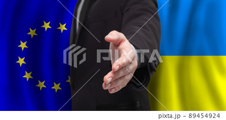 Hand on European Union and Ukrainian flags background Hand on European Union and Ukrainian flags background 89454924