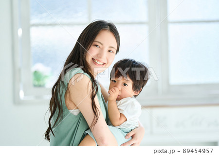 1歳半の男の子を抱っこする20代女性 89454957
