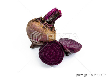Whole leafless raw red beet root and a beet cut in half on a white surface. Fresh and healthy vegetables concept. 89455487