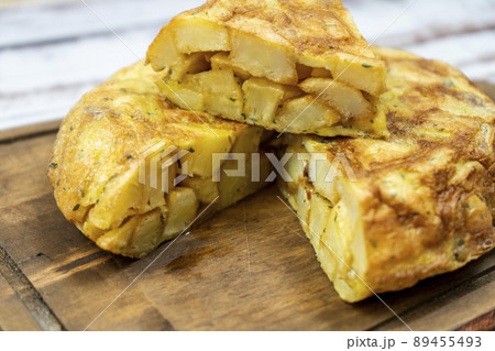 Close-up of a cut portion of a typical Spanish potato omelette in a rustic setting. Spanish Cuisine. Normal view. Close-up of a cut portion of a typical Spanish potato omelette in a rustic setting. Spanish Cuisine. Normal view. 89455493