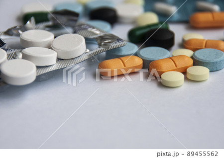 Assorted pharmaceutical medicine pills, tablets and capsules with blurred background over white background. Concept of healthcare and medicine. Assorted pharmaceutical medicine pills, tablets and capsules with blurred background over white background. Concept of healthcare and medicine. 89455562