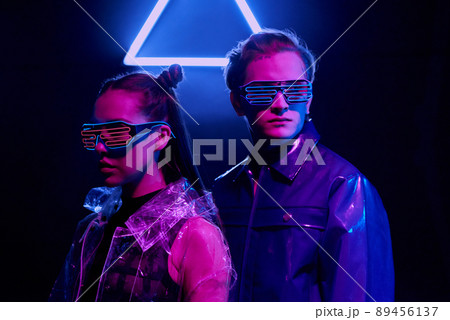 Serious young people in neon wire goggles standing in cyberspace and protecting security data 89456137