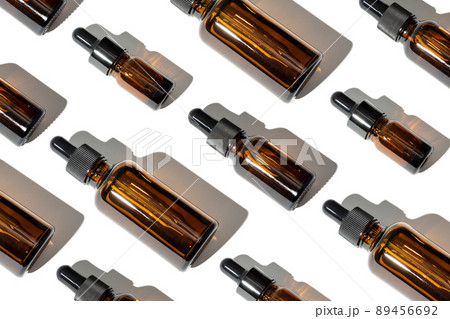 Group of Essential oil glass bottle with pipette. Variation of amber bottles. Pattern background 89456692