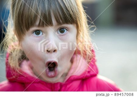 Portrait of a pretty child girl making amazed shoked expression on her face outdoors. Portrait of a pretty child girl making amazed shoked expression on her face outdoors. 89457008