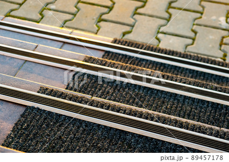 Closeup of ceramic tiles covering porch stairs with rubber anti slippery stripes on it. Closeup of ceramic tiles covering porch stairs with rubber anti slippery stripes on it. 89457178