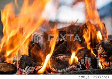 Close up of brightly burning wooden logs with yellow hot flames of fire at night. 89457284