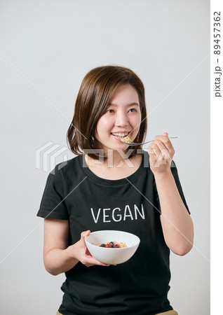 オートミールを食べる若いヴィーガン女性 89457362