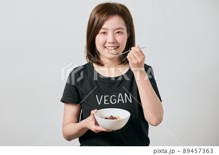 オートミールを食べる若いヴィーガン女性 オートミールを食べる若いヴィーガン女性 89457363