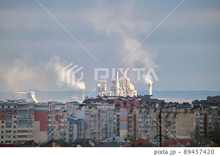 Cement plant with high factory structure and tower cranes at industrial production area near city urban area. Manufacture and global industry concept 89457420
