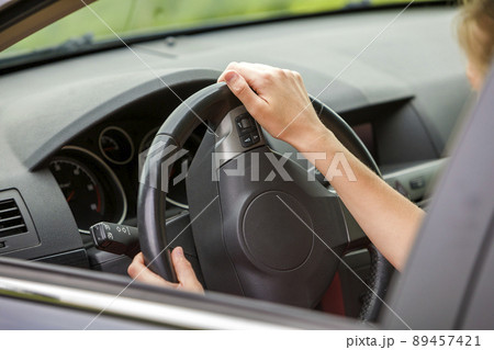 Car interior. Dashboard and woman hands on steering wheel driving a car. 89457421