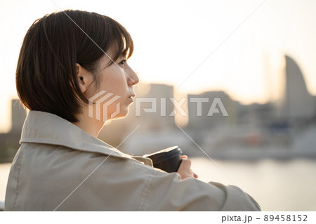 屋外でコーヒーを飲みながら物思いにふける女性の様子 屋外でコーヒーを飲みながら物思いにふける女性の様子 89458152