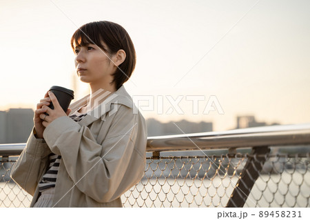 屋外でコーヒーを飲みながら物思いにふける女性の様子 屋外でコーヒーを飲みながら物思いにふける女性の様子 89458231