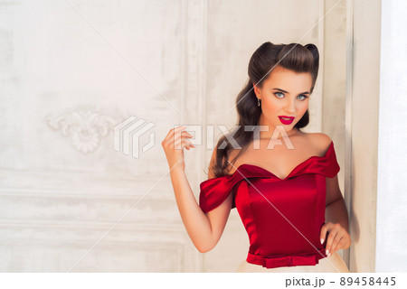 Pretty coquettish pin-up girl in retro interior 89458445