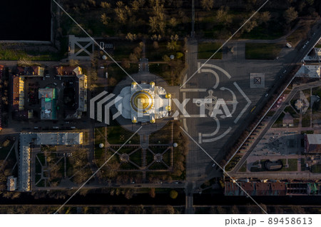 Aerial view of the sea capital of Russia Kronstadt at sunset, the golden dome of the huge main naval cathedral of St. Nicholas, the seaport with warships, dry docks, fortifications with cranes 89458613