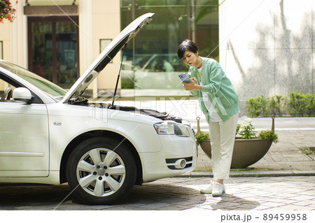 車の故障で電話をする若い女性 車の故障で電話をする若い女性 89459958
