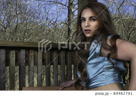 young woman outside wearing blue silk camisole hand on hip at the park young woman outside wearing blue silk camisole hand on hip at the park 89462791