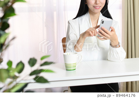 スマートフォンを持つ笑顔のアジア人女性 89464176