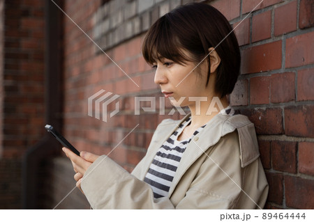 スマホを手にする女性の様子 89464444