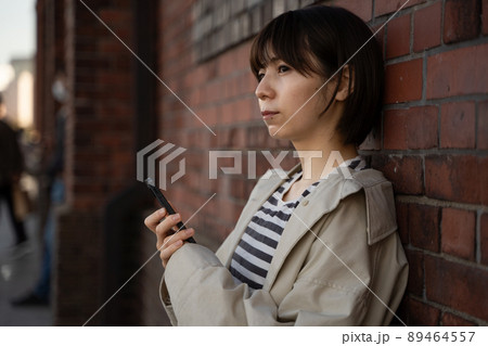 スマホを手にする女性の様子 89464557