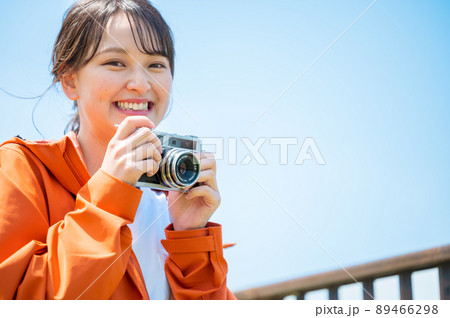 晴れた屋外でレトロなフィルムカメラで趣味の写真を撮る若い女性 晴れた屋外でレトロなフィルムカメラで趣味の写真を撮る若い女性 89466298