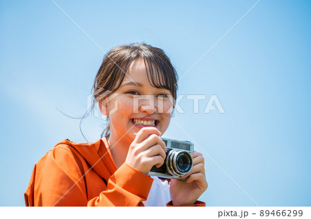 晴れた屋外でレトロなフィルムカメラで趣味の写真を撮る若い女性 晴れた屋外でレトロなフィルムカメラで趣味の写真を撮る若い女性 89466299