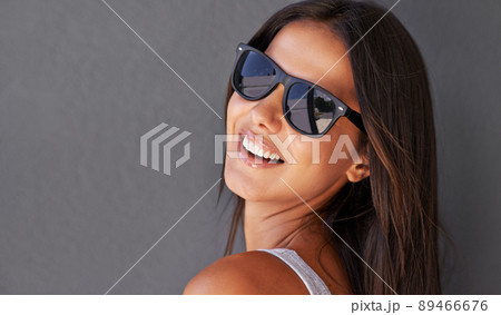 Looking confident in those shades. Shot of an attractive young woman wearing sunglasses. 89466676