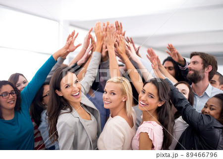 High five for business success. Shot of a group of businesspeople raising their hands in a huddle. 89466796