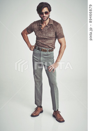 I'm kind of a big deal.... A handsome man in retro 70s clothing striking a pose in the studio. 89466879