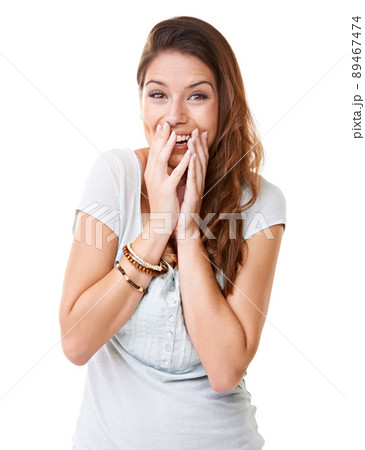 Slightly embarrassed. Cropped shot of an attractive young woman isolated on white. 89467474