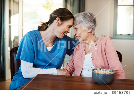 Her patient's happiness comes first. Shot of a young nurse sitting with a senior woman at breakfast time in a nursing home. 89468702