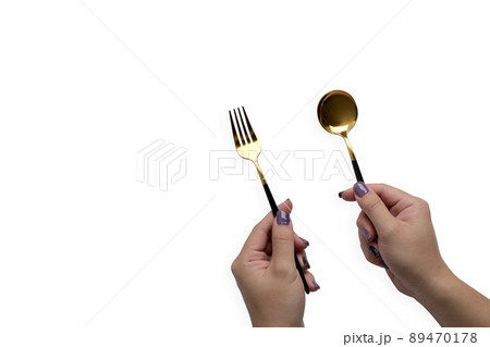 Unrecognizable woman hands holding spoon and fork on white background. 89470178