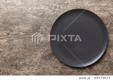 Top view of black plate on wooden background. Empty space for your design Top view of black plate on wooden background. Empty space for your design 89474623