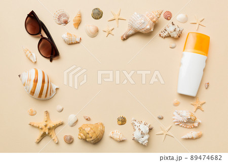 Summer time concept on colored background. Seashells from ocean shore in the shape of frame separated with space for text top view Summer time concept on colored background. Seashells from ocean shore in the shape of frame separated with space for text top view 89474682