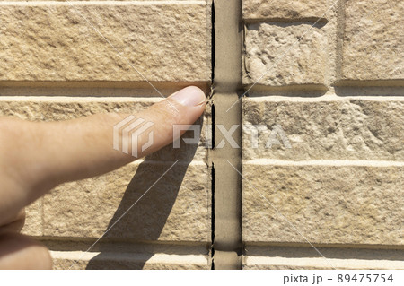 外壁のコーキングを点検する男性のイメージ 89475754