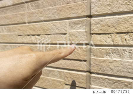 外壁のコーキングを点検する男性のイメージ 89475755