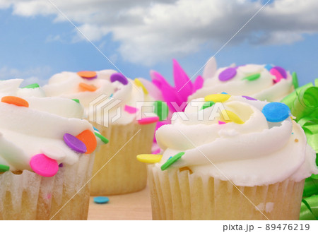 Cupcakes with white icing and Colorful Sprinkles 89476219