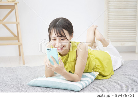 女性　スマホ　リビング 89476751