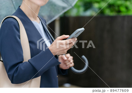 天気予報を調べる女性　梅雨　雨　 89477609