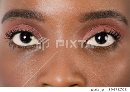 Close up, profle photo of a dark skin female eye, iris, pupil, eye lashes, eye lids. 89478708