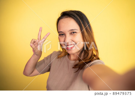 woman with peaceful hand gesture on isolated background woman with peaceful hand gesture on isolated background 89479375