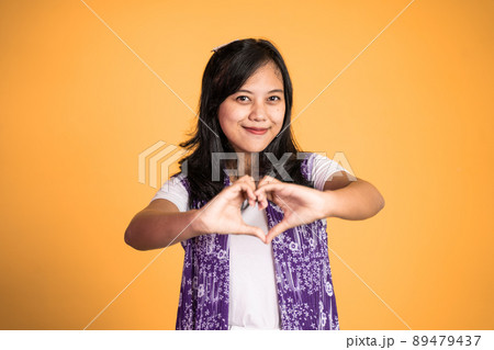 woman smiling in heart shape with fingers on isolated woman smiling in heart shape with fingers on isolated 89479437