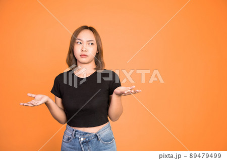 asian woman opening two palms feeling uncertain 89479499