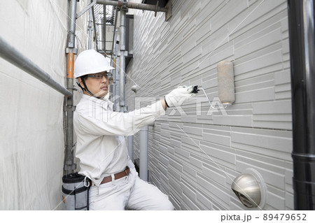 足場にのってローラーで戸建て住宅の外壁を塗る塗装職人 足場にのってローラーで戸建て住宅の外壁を塗る塗装職人 89479652