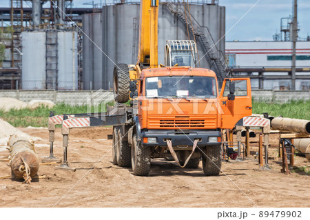Construction work on pipe laying of pipeline into trench using a crane Construction work on pipe laying of pipeline into trench using a crane 89479902