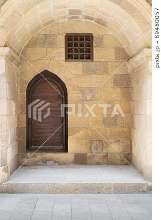 Wooden aged vaulted ornate in a recessed stone wall, Medieval Cairo, Egypt 89480057