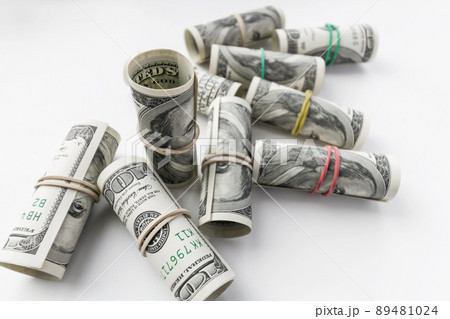 American one hundred dollar banknotes rolled up as a tubule. Light background, closeup, selective focus 89481024
