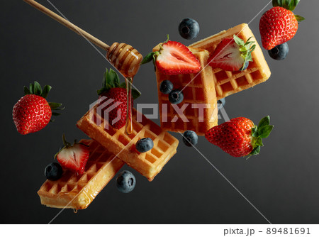 Waffles with blueberries, strawberries, and honey. Waffles with blueberries, strawberries, and honey. 89481691