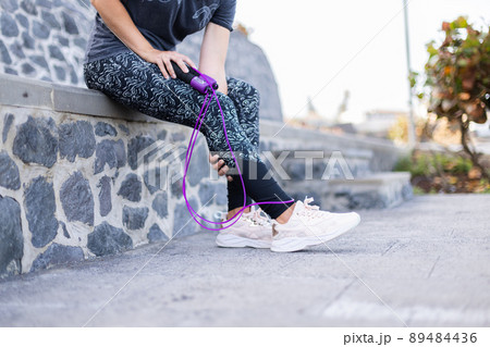 Young woman with a skipping rope. Muscle ache after jumping with a skipping rope. Young woman with a skipping rope. Muscle ache after jumping with a skipping rope. 89484436