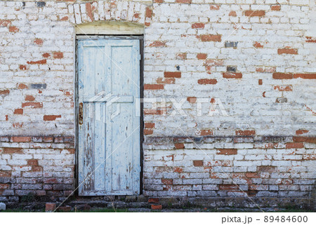 Old wooden front door on brick wall background Old wooden front door on brick wall background 89484600