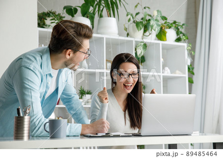 A woman and a man are happy about a successful deal in the office. A woman and a man are happy about a successful deal in the office. 89485464